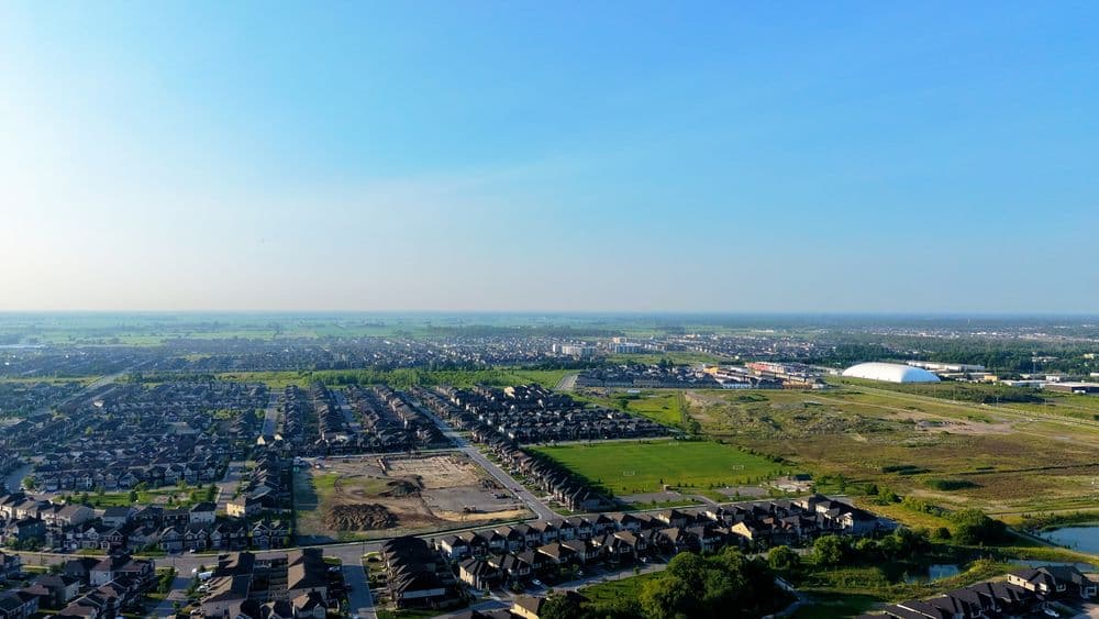 Aerial view of a residential neighborhood bordered by open land ready for development.